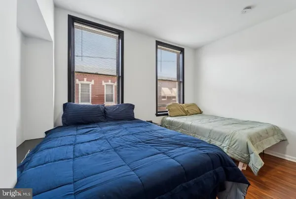 a bedroom with a large bed and two windows