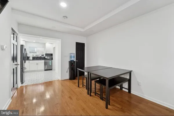 a kitchen with stainless steel appliances refrigerator dining table and chairs