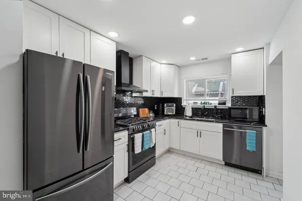 a kitchen with stainless steel appliances granite countertop a refrigerator stove a sink and a microwave