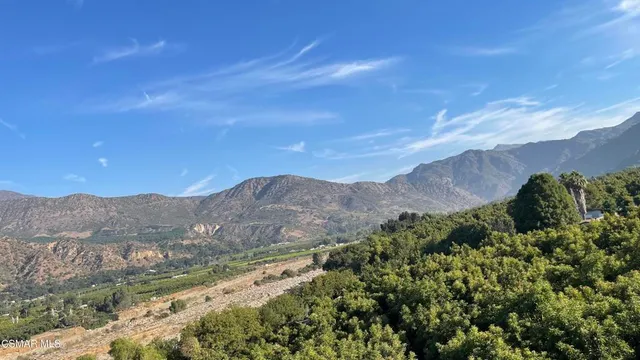 a view of a mountain range with a lush green hillside