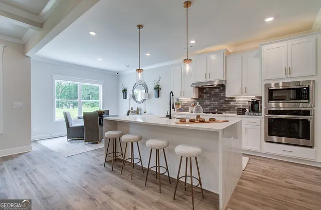 a kitchen with kitchen island granite countertop a sink a counter space appliances and cabinets