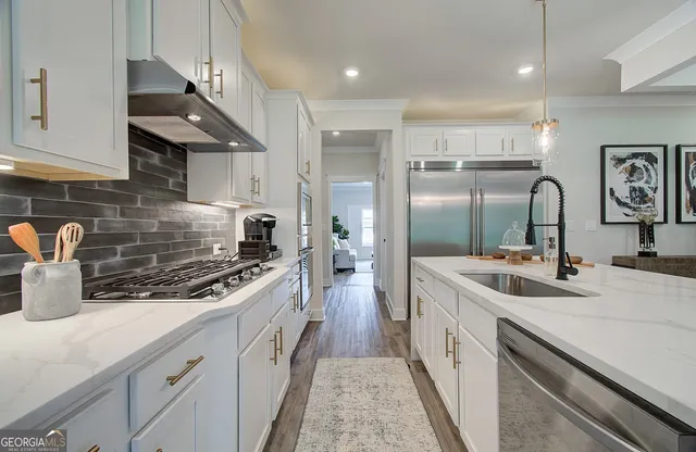 a kitchen with stainless steel appliances granite countertop a sink stove and refrigerator