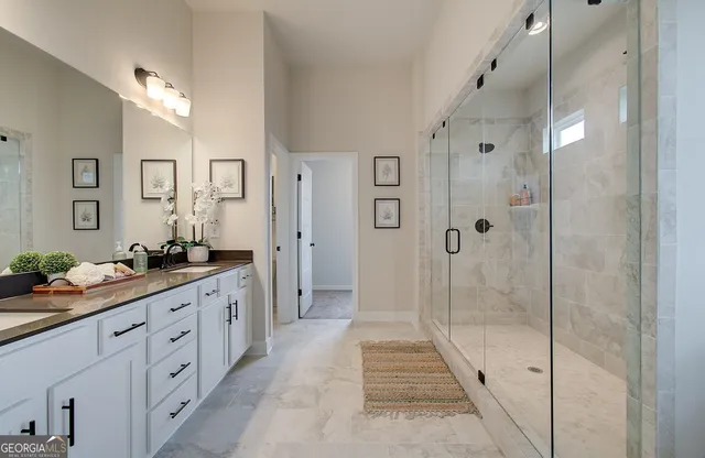 a spacious bathroom with a granite countertop sink a mirror a shower and a bathtub