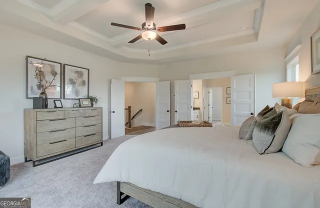 a spacious bedroom with a bed a dresser and a chandelier