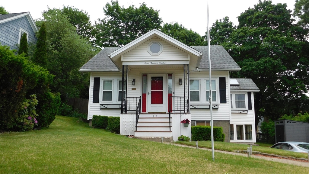414 Cedar Street Dedham, MA 02026 - Photo 2 of 24 a front view of a house with a yard