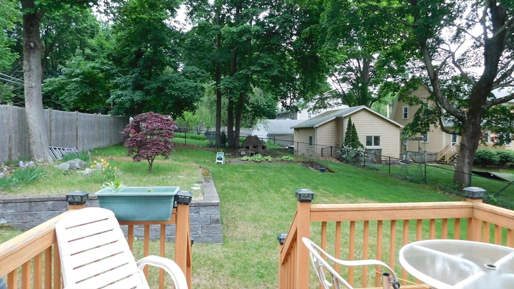 414 Cedar Street Dedham, MA 02026 - Photo 6 of 24 a view of backyard with a table and chairs potted plants and large tree