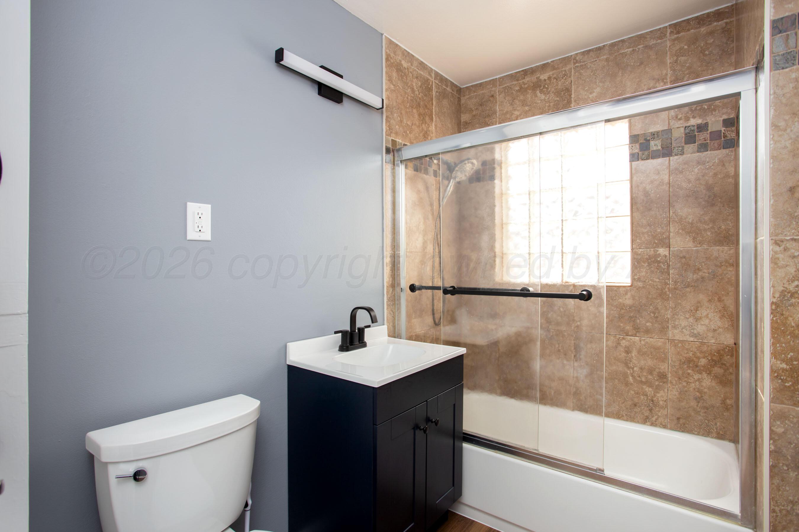 4815 Southwest 10th Avenue Amarillo, TX 79106 - Photo 14 of 21 a bathroom with a sink a toilet and shower