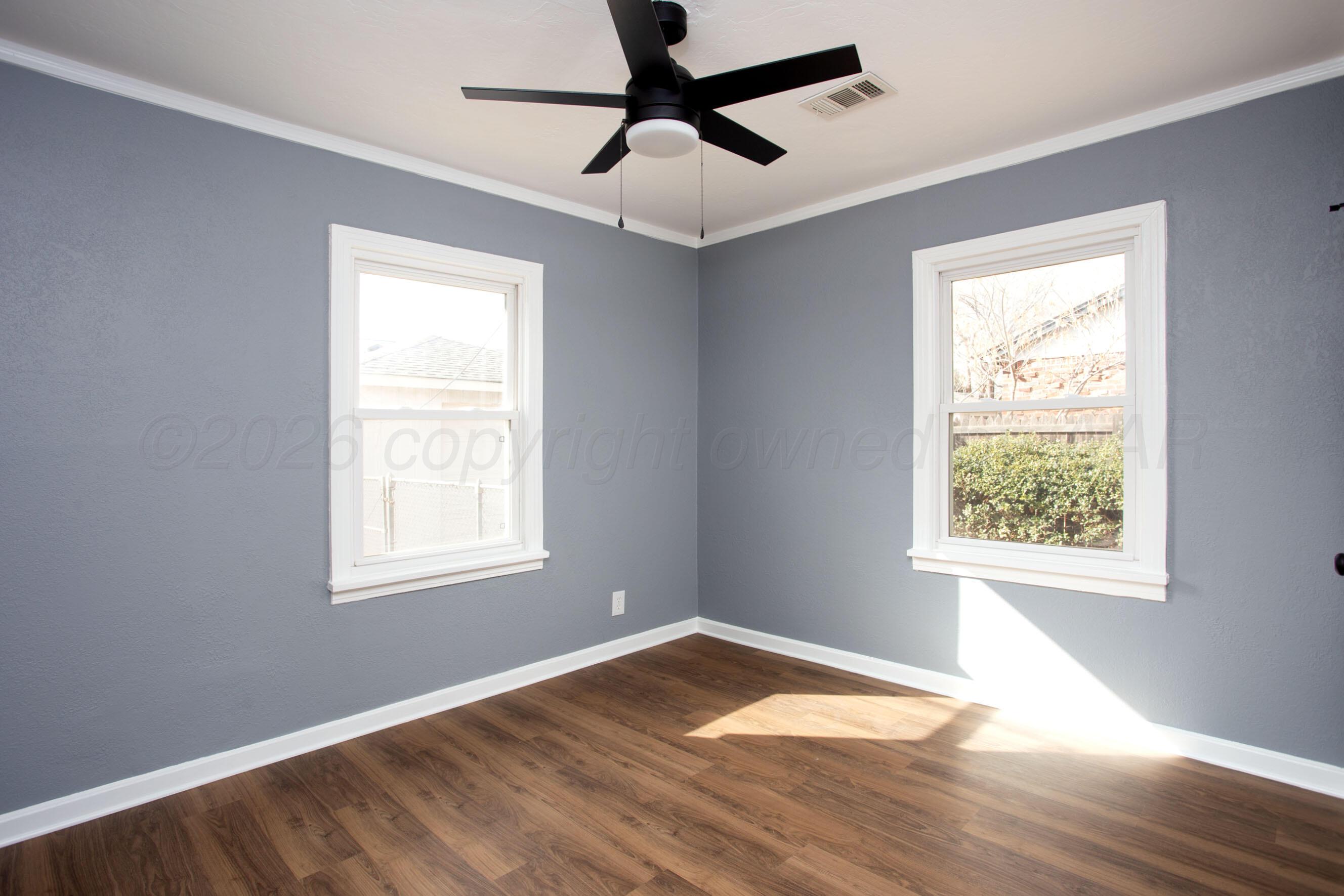 4815 Southwest 10th Avenue Amarillo, TX 79106 - Photo 16 of 21 a view of an empty room with wooden floor and a window