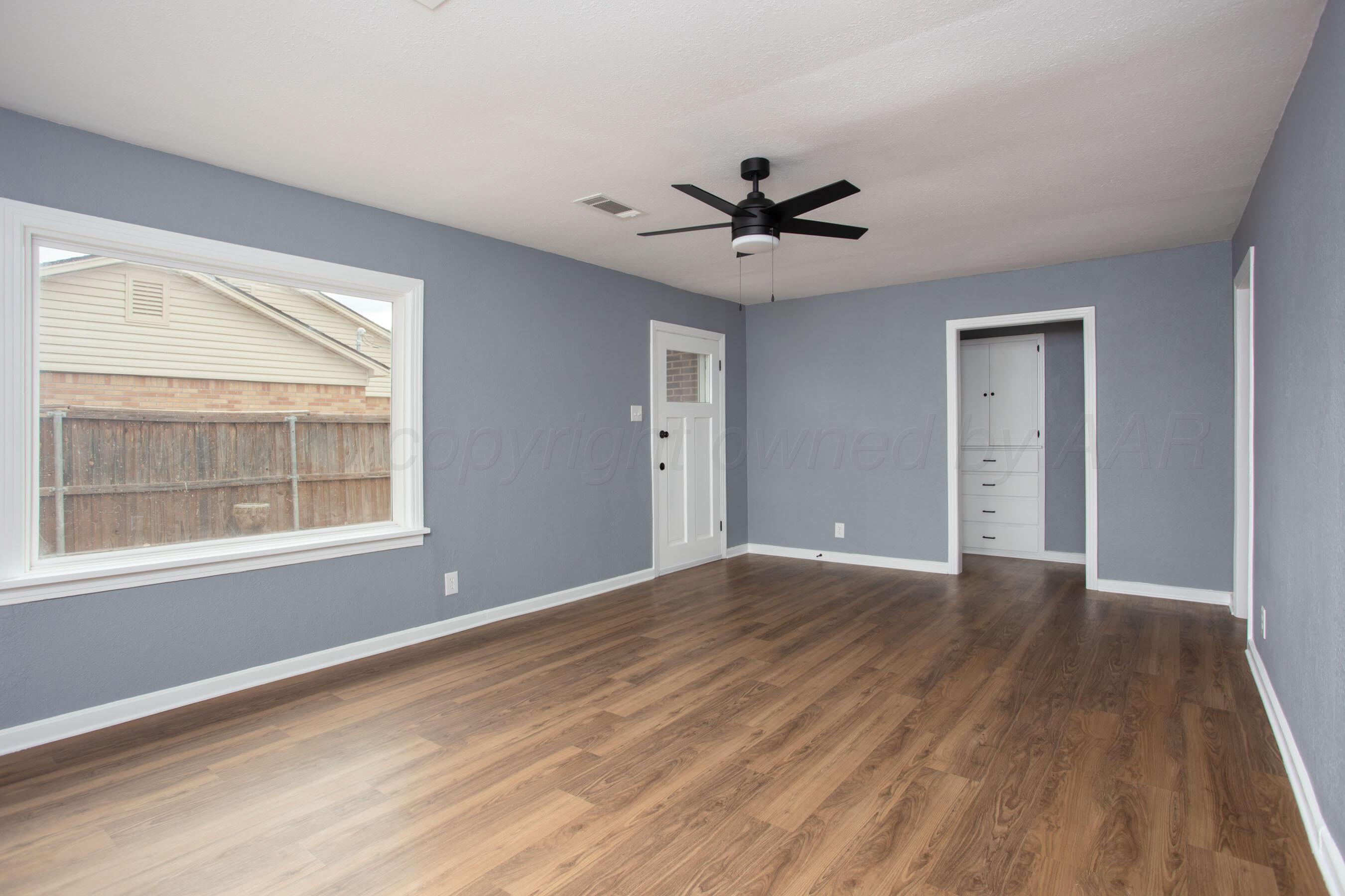 4815 Southwest 10th Avenue Amarillo, TX 79106 - Photo 2 of 21 a view of an empty room with wooden floor and a window