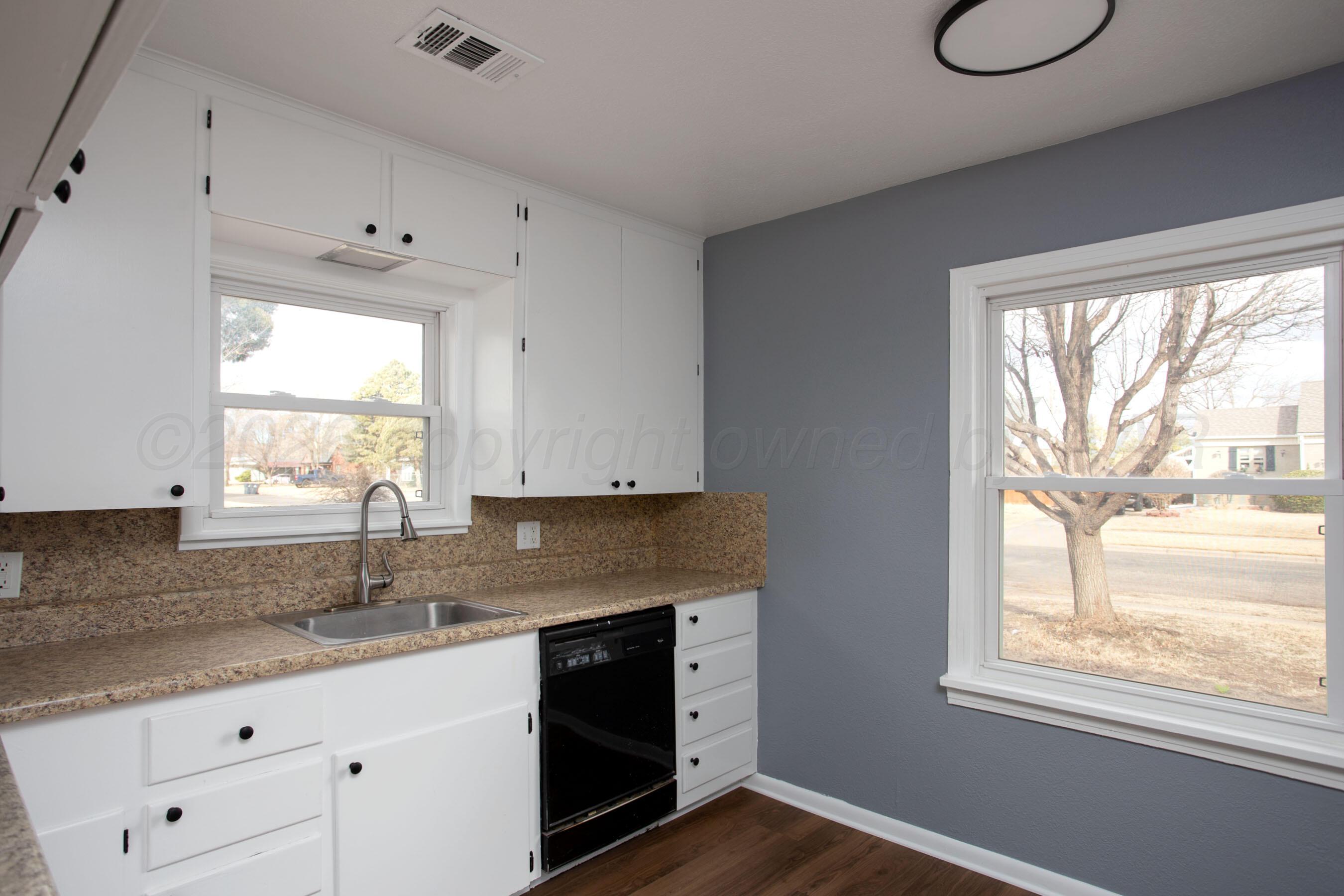 4815 Southwest 10th Avenue Amarillo, TX 79106 - Photo 9 of 21 a kitchen with granite countertop white cabinets window and sink