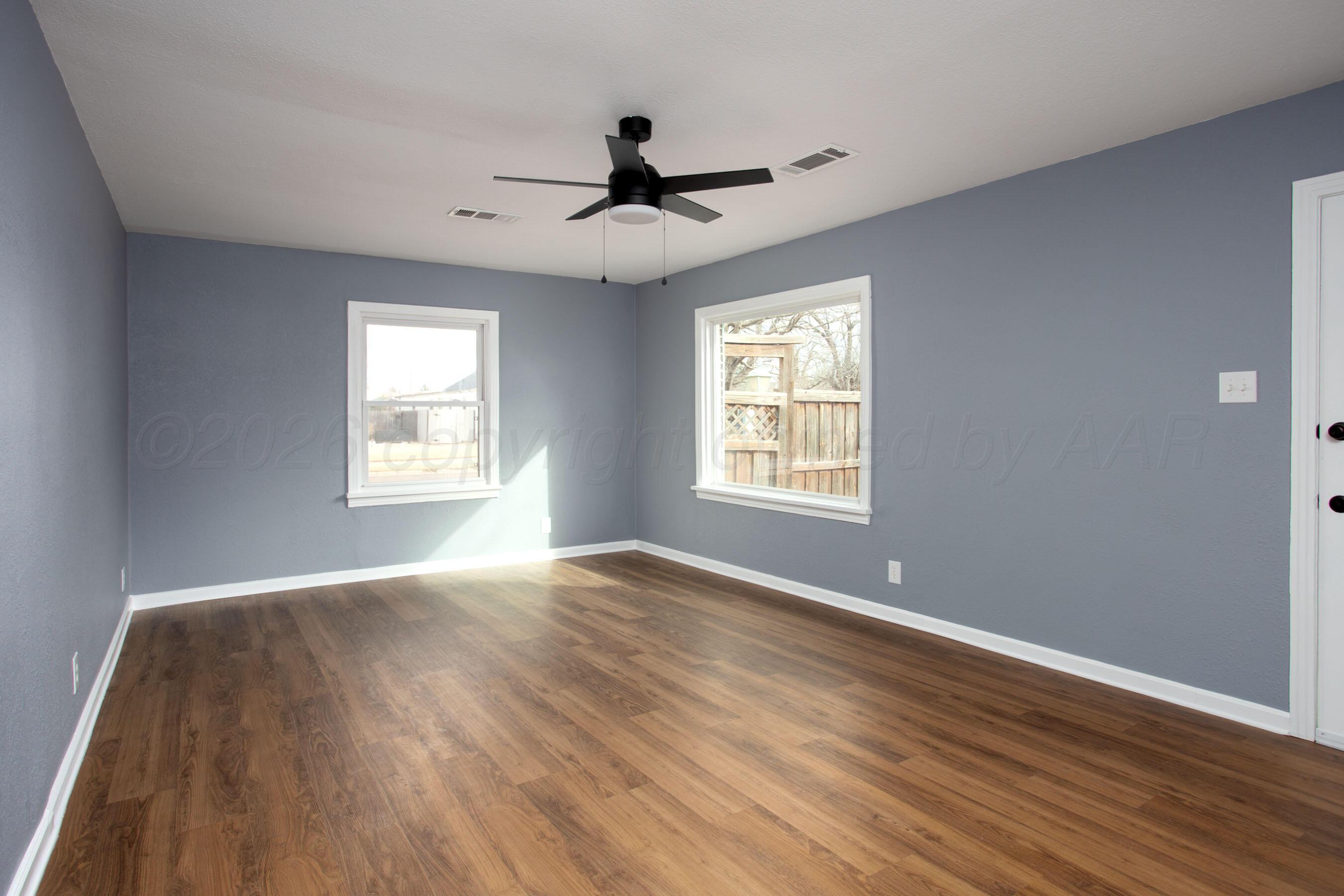 4815 Southwest 10th Avenue Amarillo, TX 79106 - Photo 10 of 21 a view of an empty room with wooden floor and a window