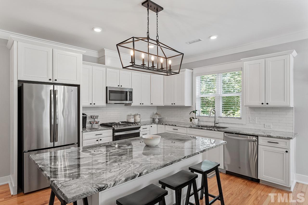 1417 Battery Drive Raleigh, NC 27610 - Photo 14 of 34 a kitchen with stainless steel appliances granite countertop a sink a stove a refrigerator cabinets and a dining table