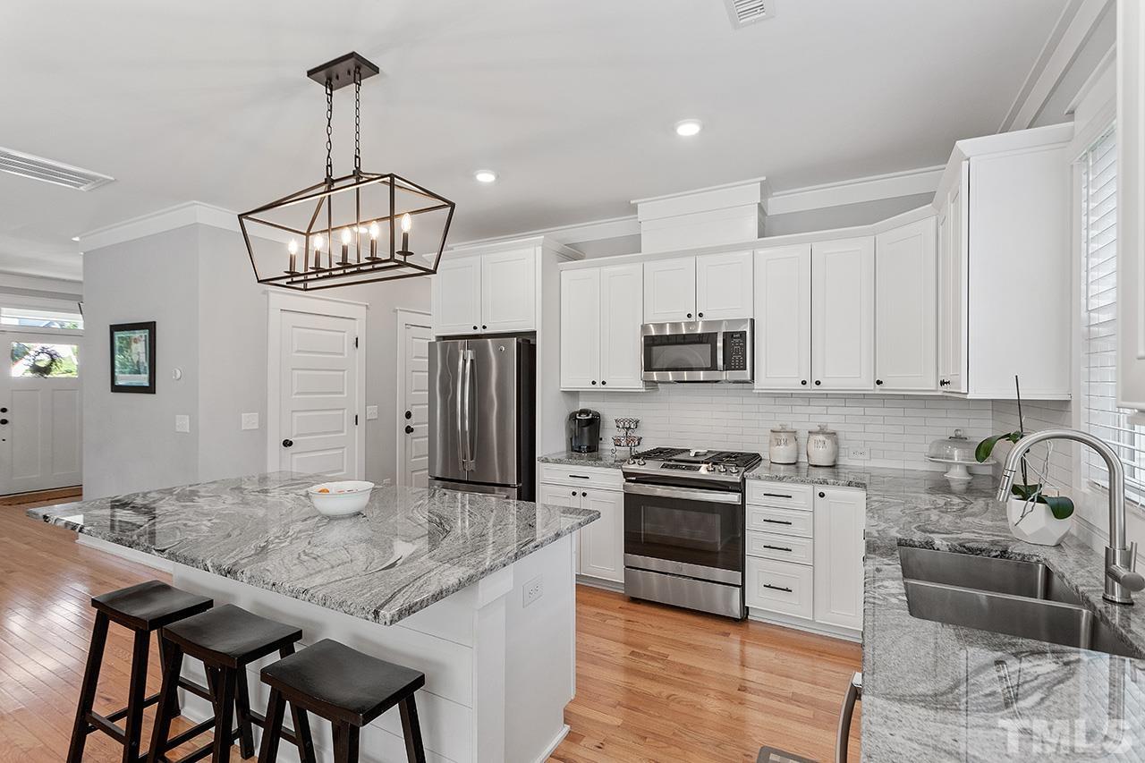 1417 Battery Drive Raleigh, NC 27610 - Photo 15 of 34 a kitchen with stainless steel appliances granite countertop a kitchen island a stove a table and chairs