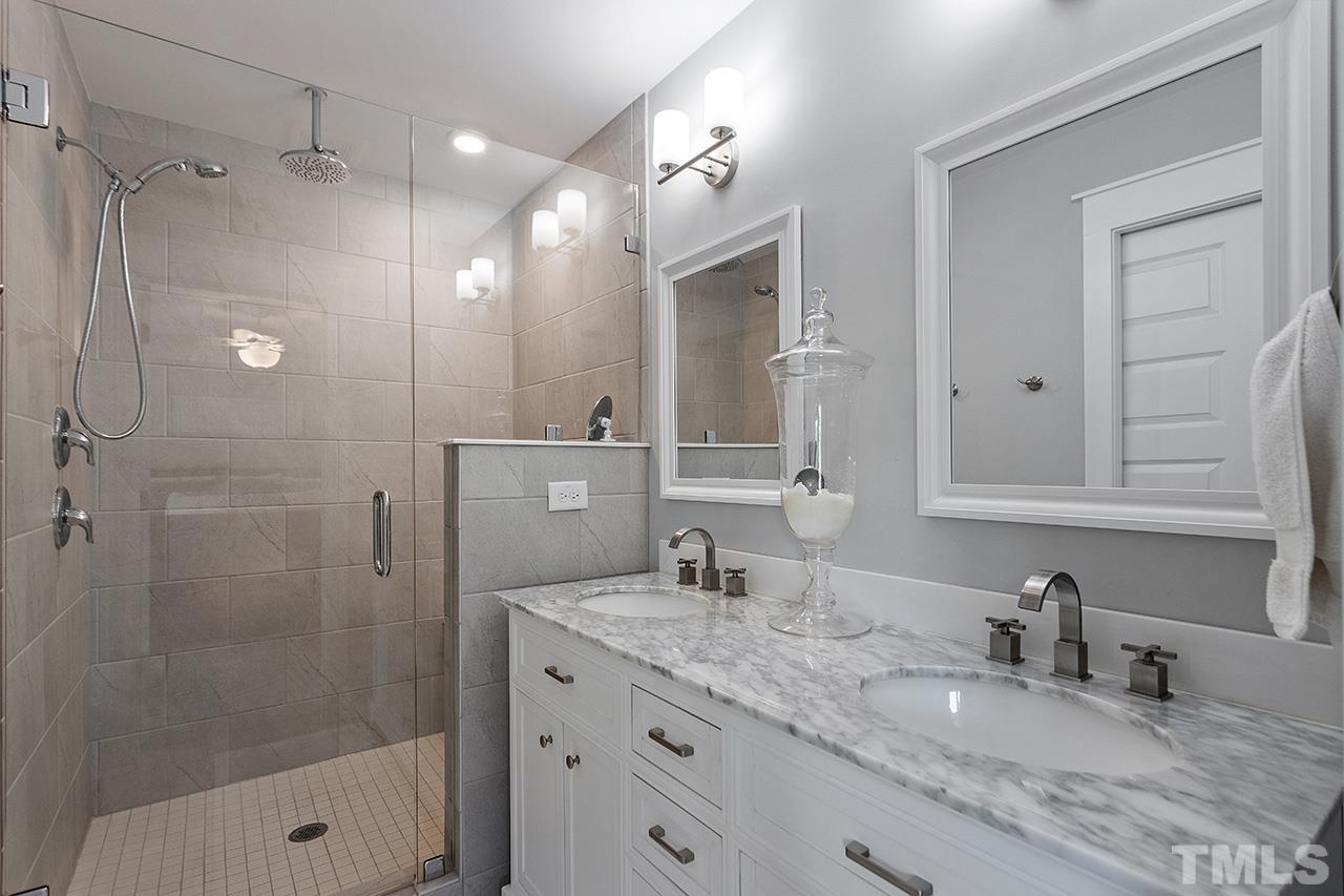 1417 Battery Drive Raleigh, NC 27610 - Photo 22 of 34 a bathroom with a granite countertop sink a mirror a shower and a mirror