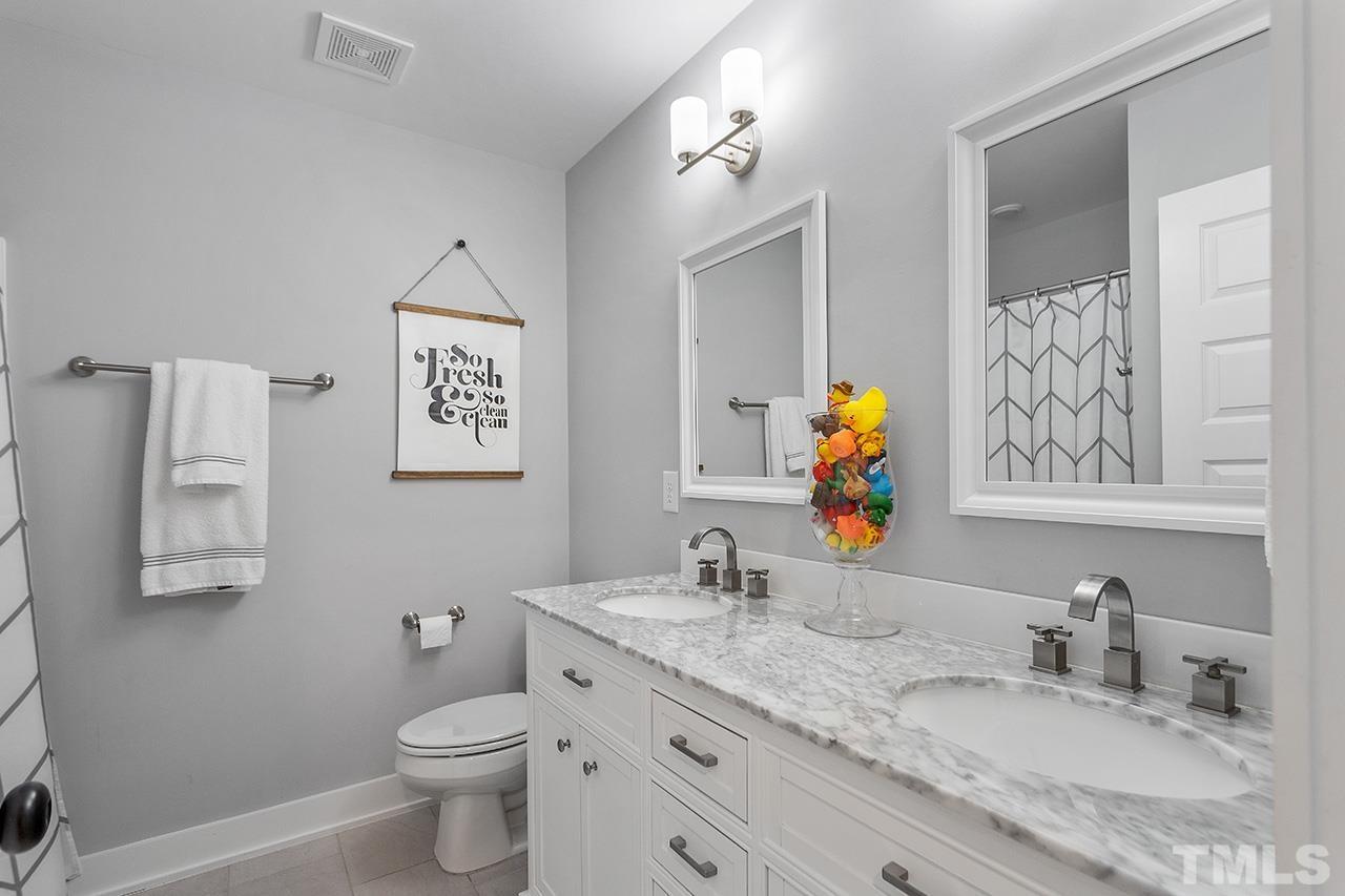 1417 Battery Drive Raleigh, NC 27610 - Photo 26 of 34 a bathroom with double vanity sink toilet and a mirror