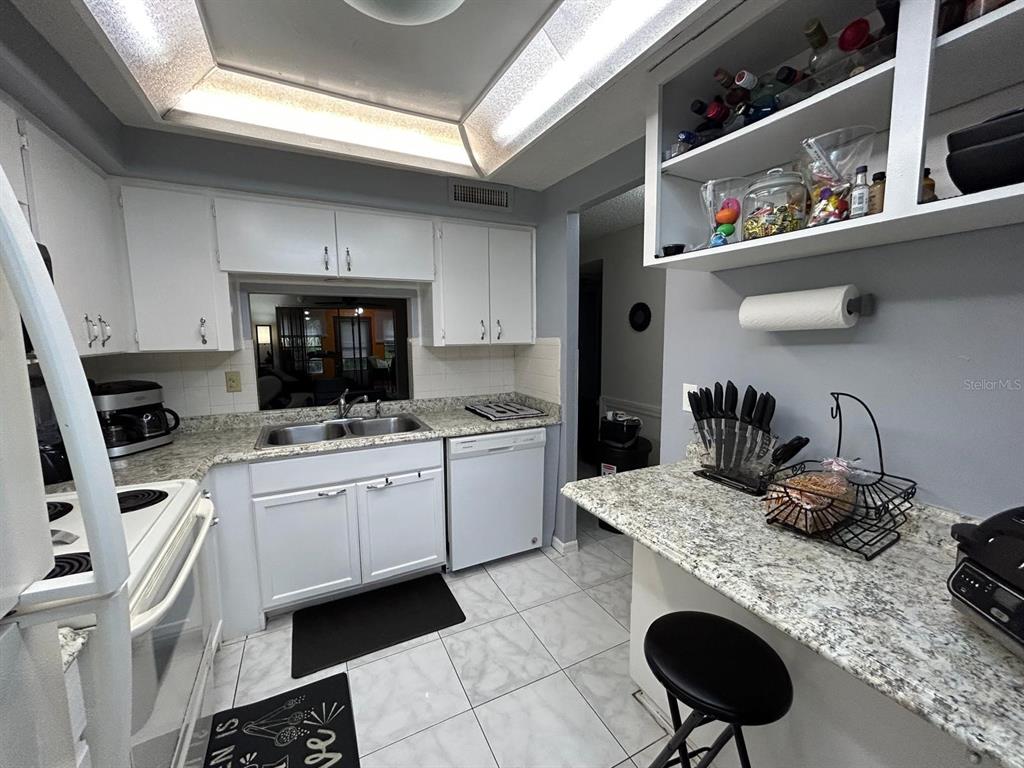 Undisclosed Address New Port Richey, FL 34652 - Photo 7 of 25 a kitchen with a sink a stove and cabinets