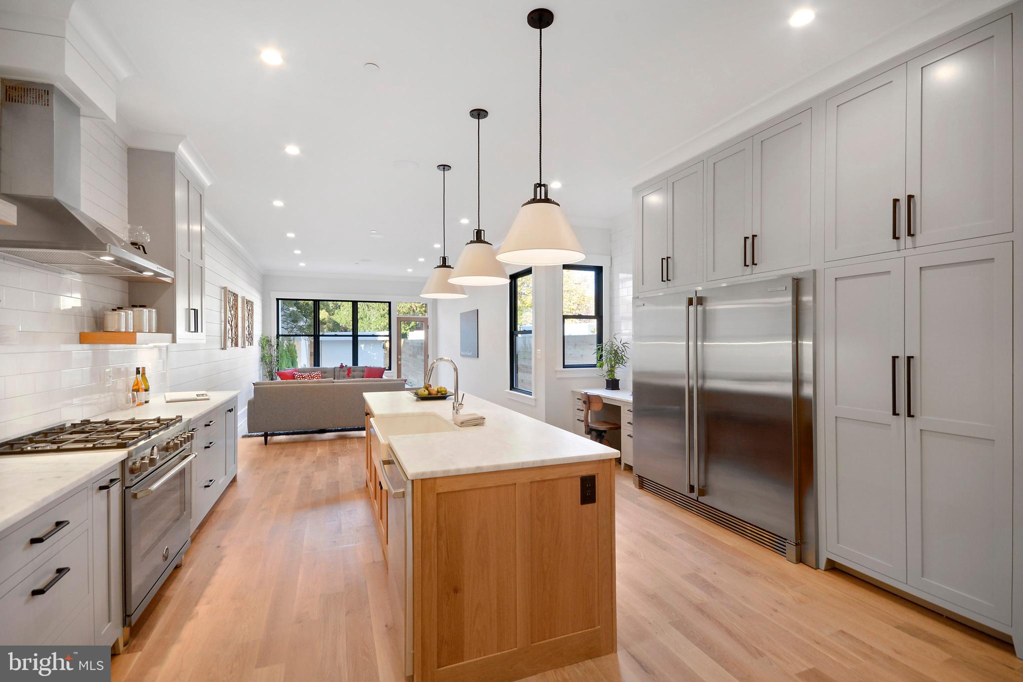 1432 G Street Southeast Washington, DC 20003 - Photo 5 of 35 a kitchen with stainless steel appliances granite countertop a refrigerator a sink dishwasher a oven and a dining table with wooden floor