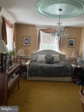 a living room with furniture a flat screen tv and floor to ceiling window