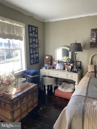 a bedroom with a bed a flat tv screen and dresser