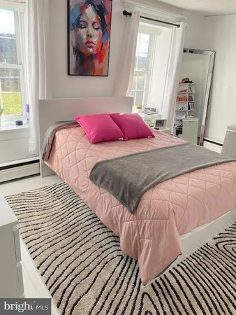 a bedroom with a bed and a painting on the wall