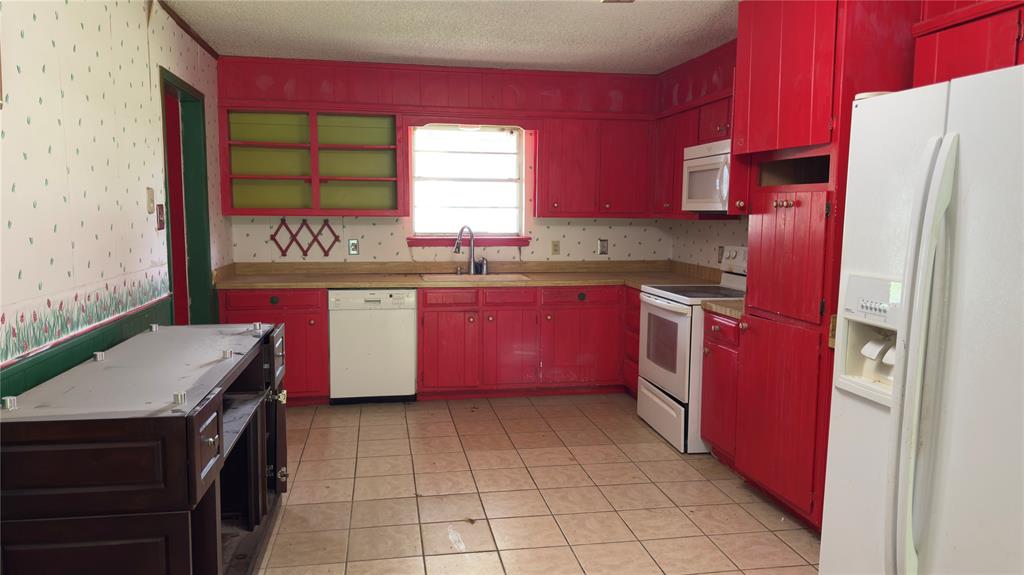 415 Meadowlark Trail Springtown, TX 76082 - Photo 7 of 35 a kitchen with stainless steel appliances a sink stove and refrigerator