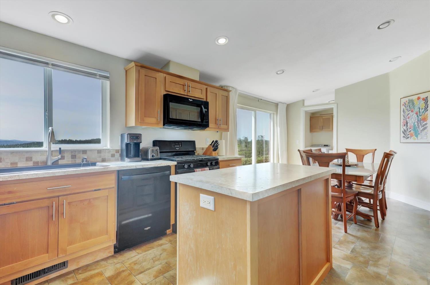 13886 Meadow Valley Road Dobbins, CA 95935 - Photo 13 of 99 a kitchen with stainless steel appliances granite countertop a sink a stove a refrigerator a dining table and chairs with wooden floor