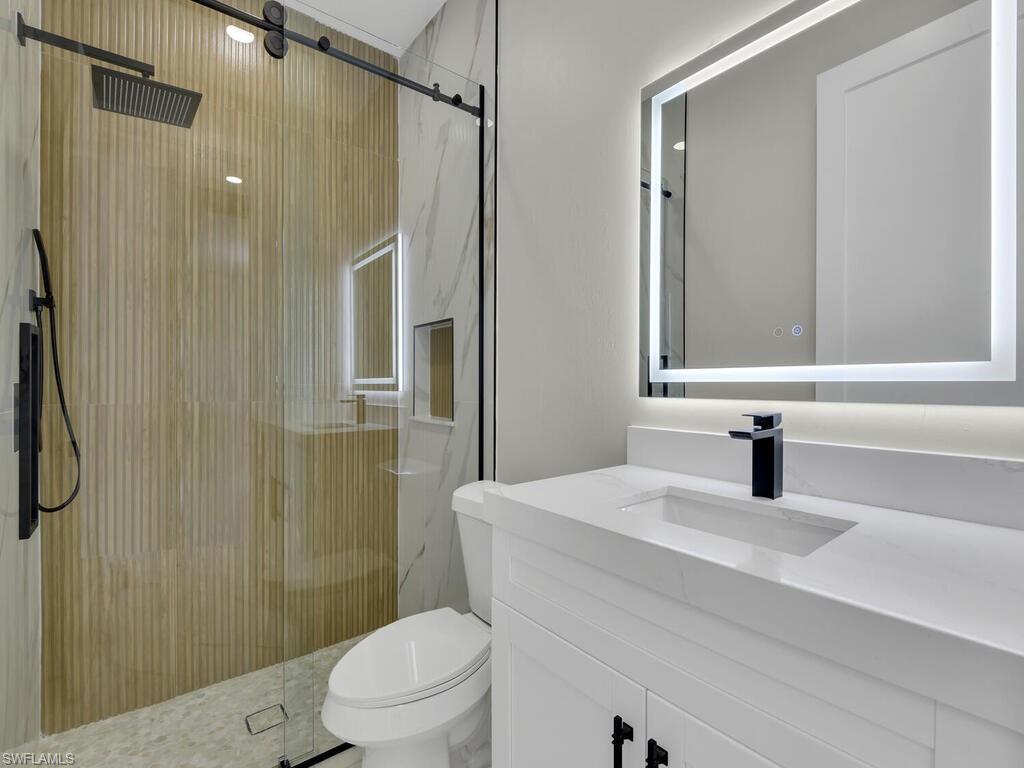 3300 3rd Street Southwest Lehigh Acres, FL 33976 - Photo 19 of 21 Bathroom featuring vanity and a marble finish shower