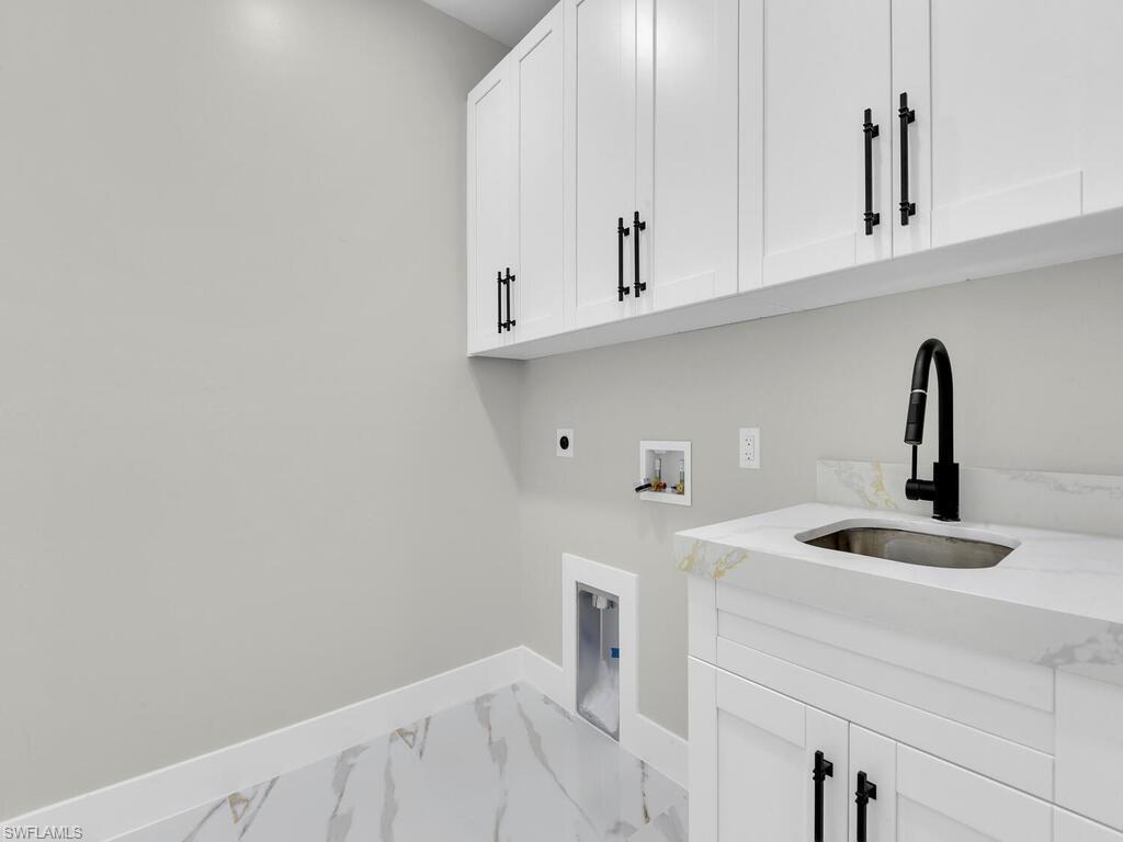 3300 3rd Street Southwest Lehigh Acres, FL 33976 - Photo 20 of 21 Washroom featuring hookup for a washing machine, electric dryer hookup, marble finish flooring, and cabinet space
