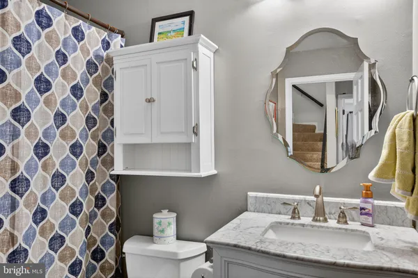a bathroom with a granite countertop sink and a mirror