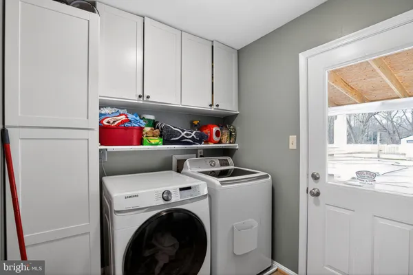 a utility room with dryer washer and a fridge