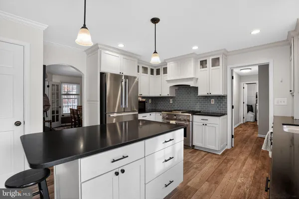 a kitchen with granite countertop a sink a counter top space appliances and cabinets