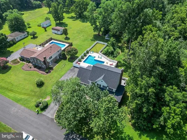 an aerial view of a house with swimming pool and garden