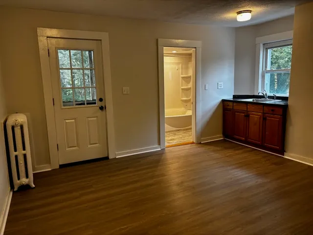 an empty room with wooden floor and windows