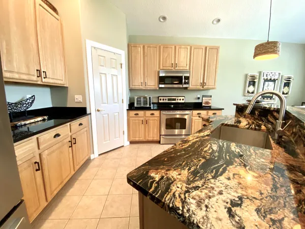a kitchen with stainless steel appliances granite countertop a stove a sink and a microwave