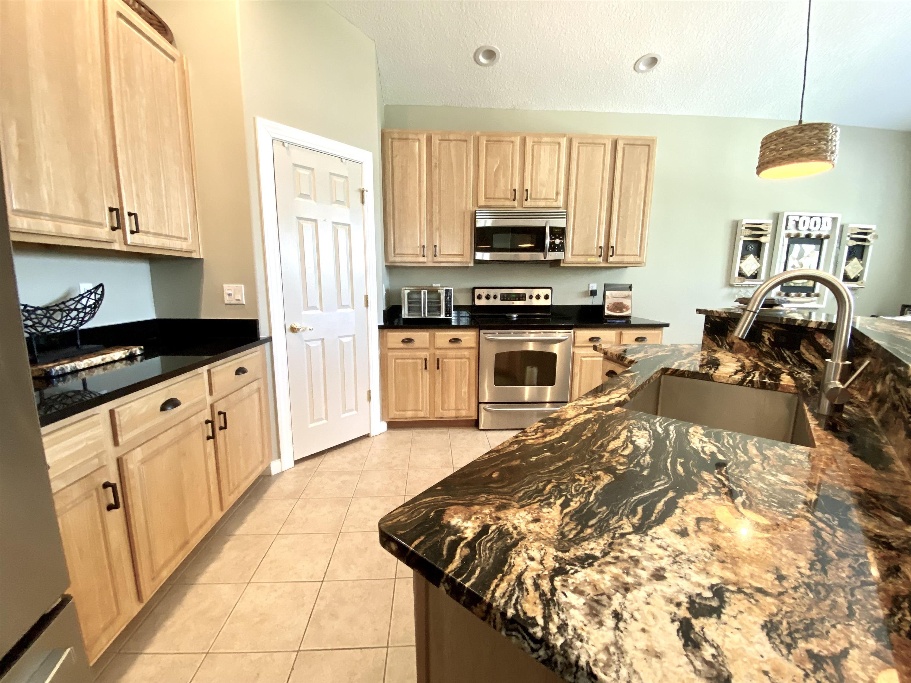 176 Sunset Circle North St. Augustine, FL 32080 - Photo 11 of 44 a kitchen with stainless steel appliances granite countertop a stove a sink and a microwave