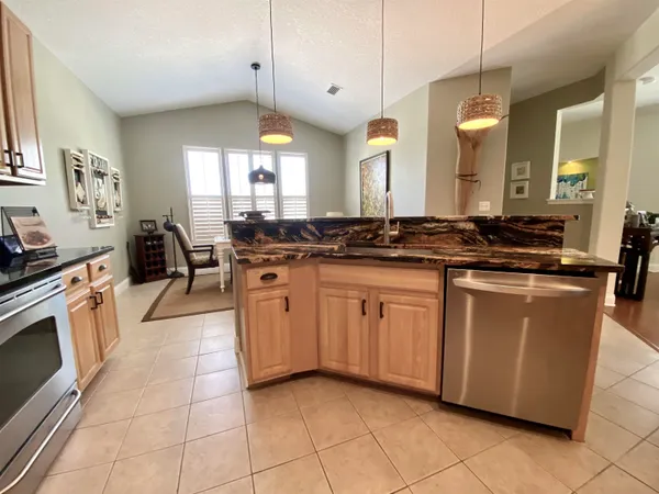 a kitchen with stainless steel appliances granite countertop a sink a stove a washer and dryer