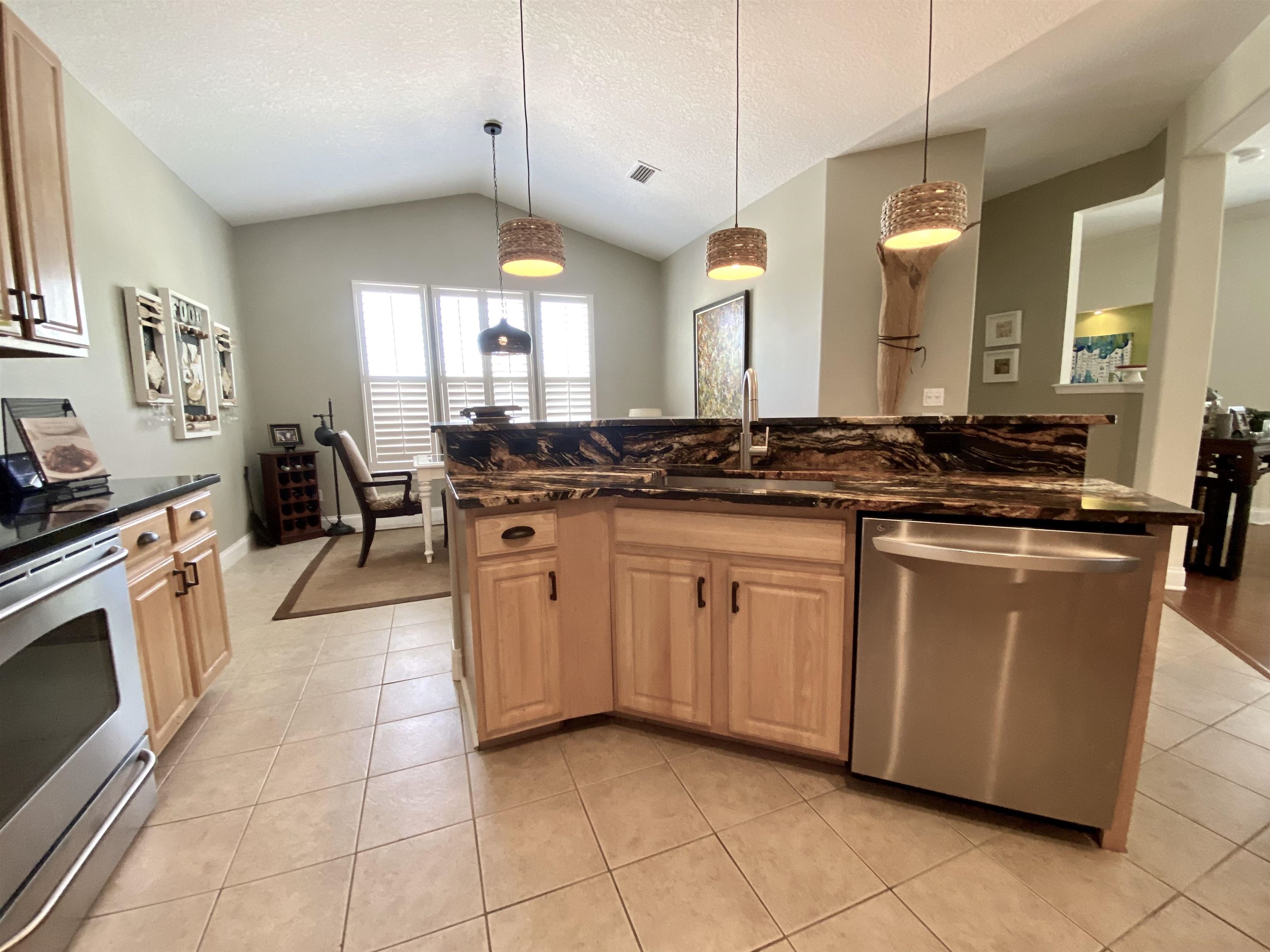 176 Sunset Circle North St. Augustine, FL 32080 - Photo 12 of 44 a kitchen with stainless steel appliances granite countertop a sink a stove a washer and dryer