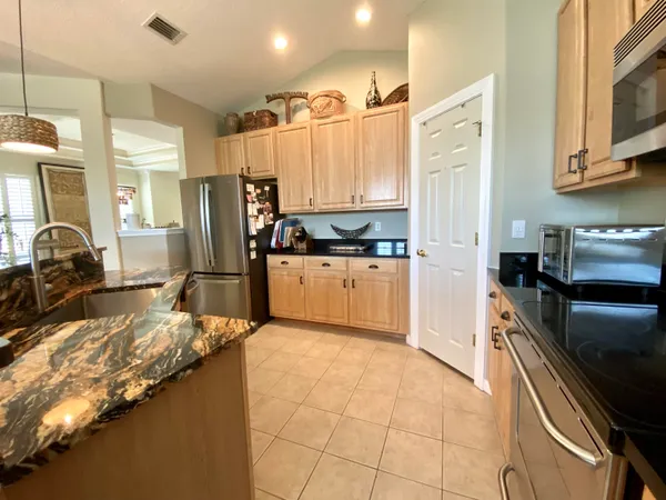 a kitchen with kitchen island granite countertop a sink stove and refrigerator
