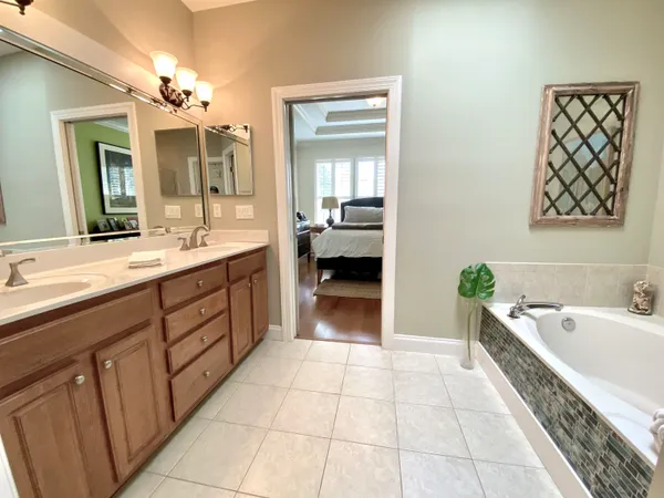 a spacious bathroom with a bathtub sink and double vanity