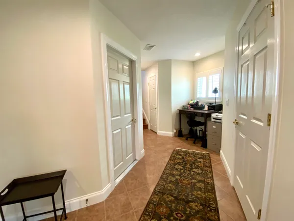 a view of a hallway to a livingroom with furniture