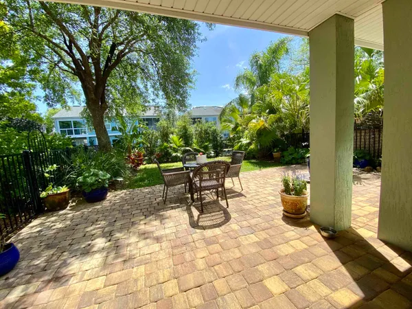a view of a patio with a table and chairs and potted plants