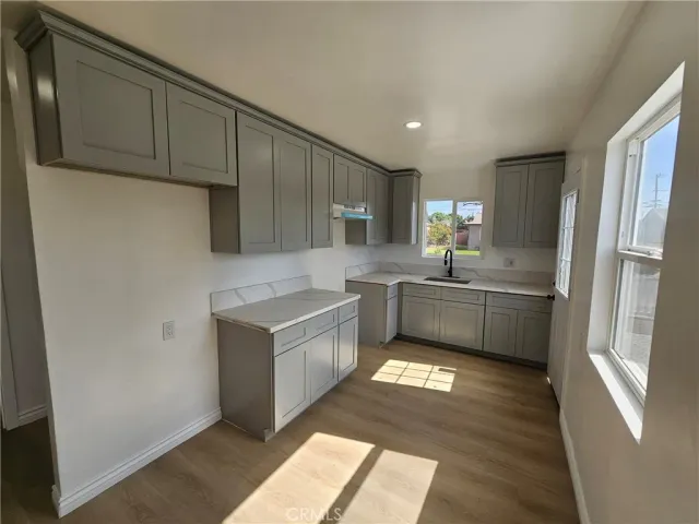 a kitchen with a sink a refrigerator and cabinets