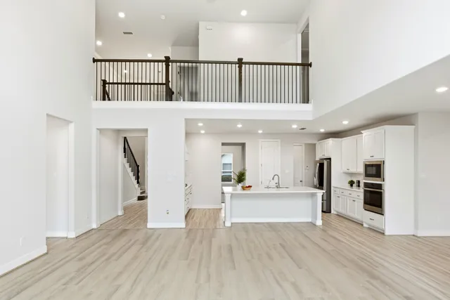 an empty room with wooden floor fireplace and windows