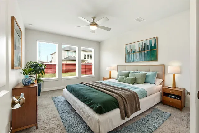 an empty room with windows and chandelier fan