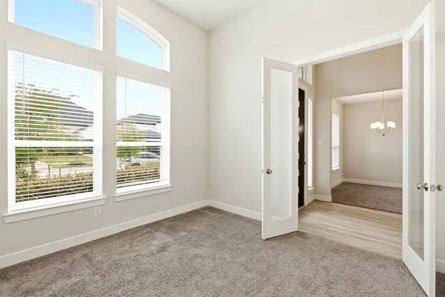 a view of an empty room with a window and fireplace