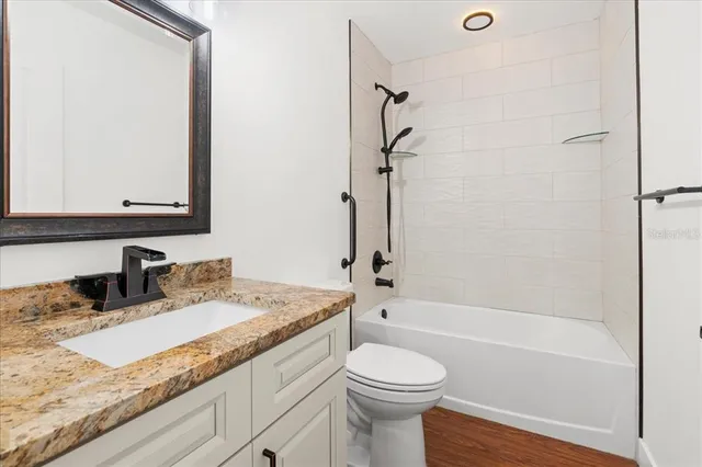 a bathroom with a granite countertop sink toilet and shower
