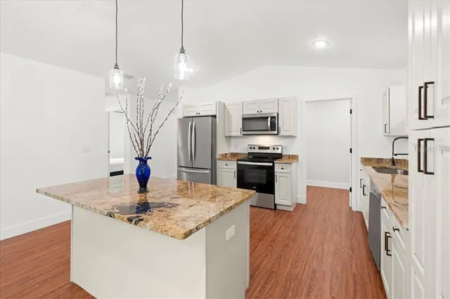 a kitchen with stainless steel appliances granite countertop a sink refrigerator and microwave