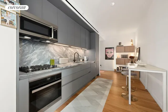 a kitchen with stainless steel appliances kitchen island granite countertop a stove and a sink