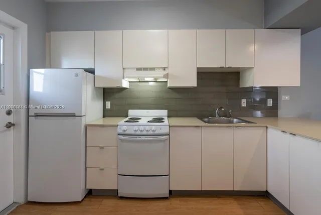 a kitchen with a refrigerator sink stove and cabinets