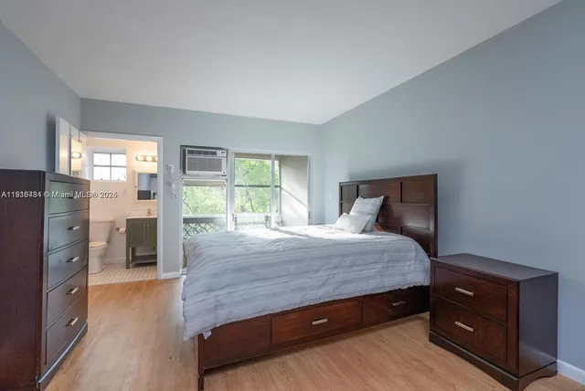 a spacious bedroom with a bed and wooden floor